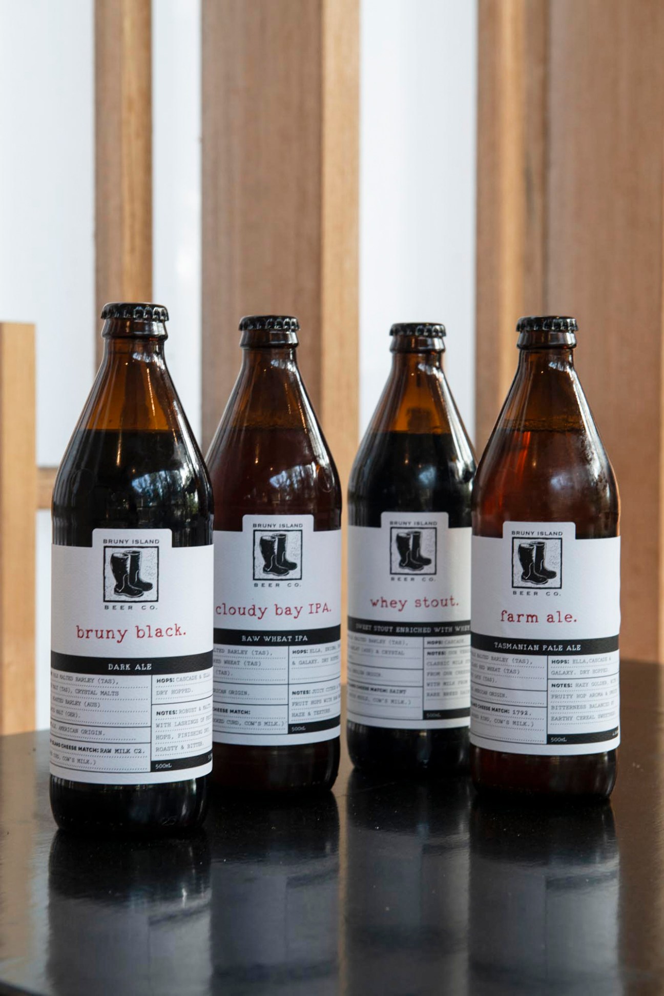 Four bottles of Bruny Island Beer Company craft beer with white labels displaying varieties like bruny black and farm ale
