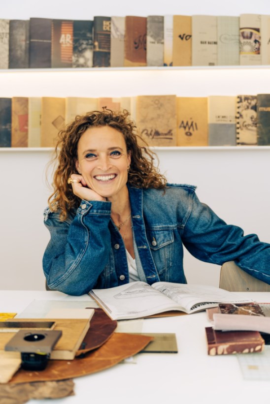 Portrait of Esther Stam, founder of Studio Modijefsky, sitting in a contemporary interior setting