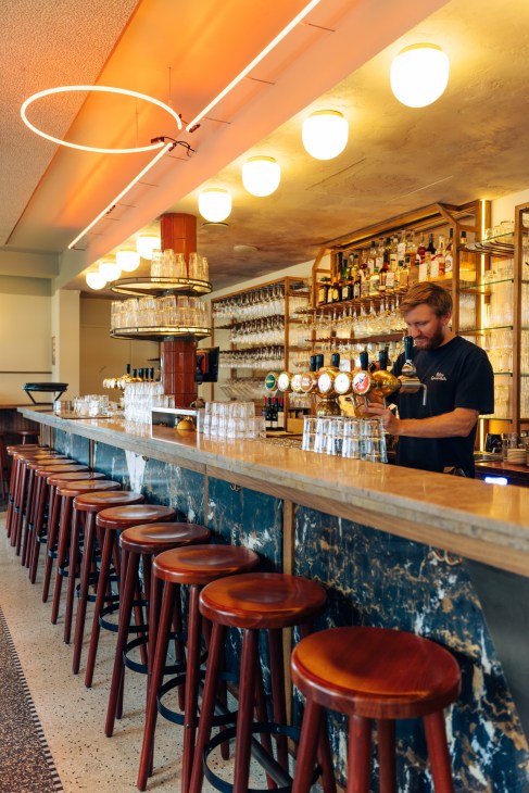 Bar area at Polly Goudvisch showing goldfish-themed design elements and modern interpretation of brown café style