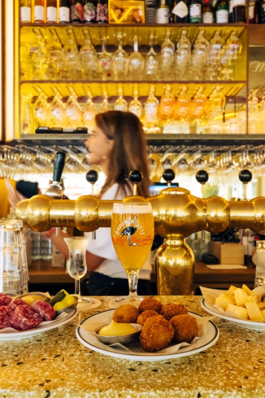 Interior of Café Marcella showing traditional brown café elements with modern touches, diners enjoying beer and bitterballen