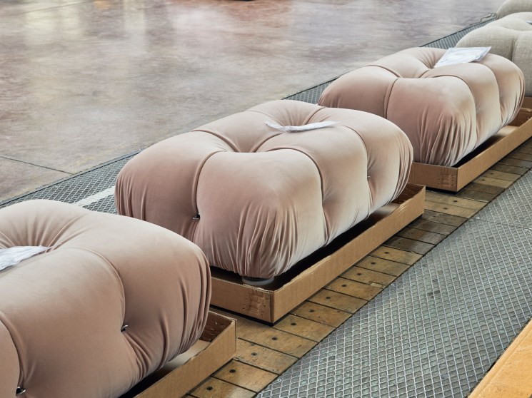 Packaged Camaleonda sofa components wrapped in beige fabric covers arranged on wooden platforms