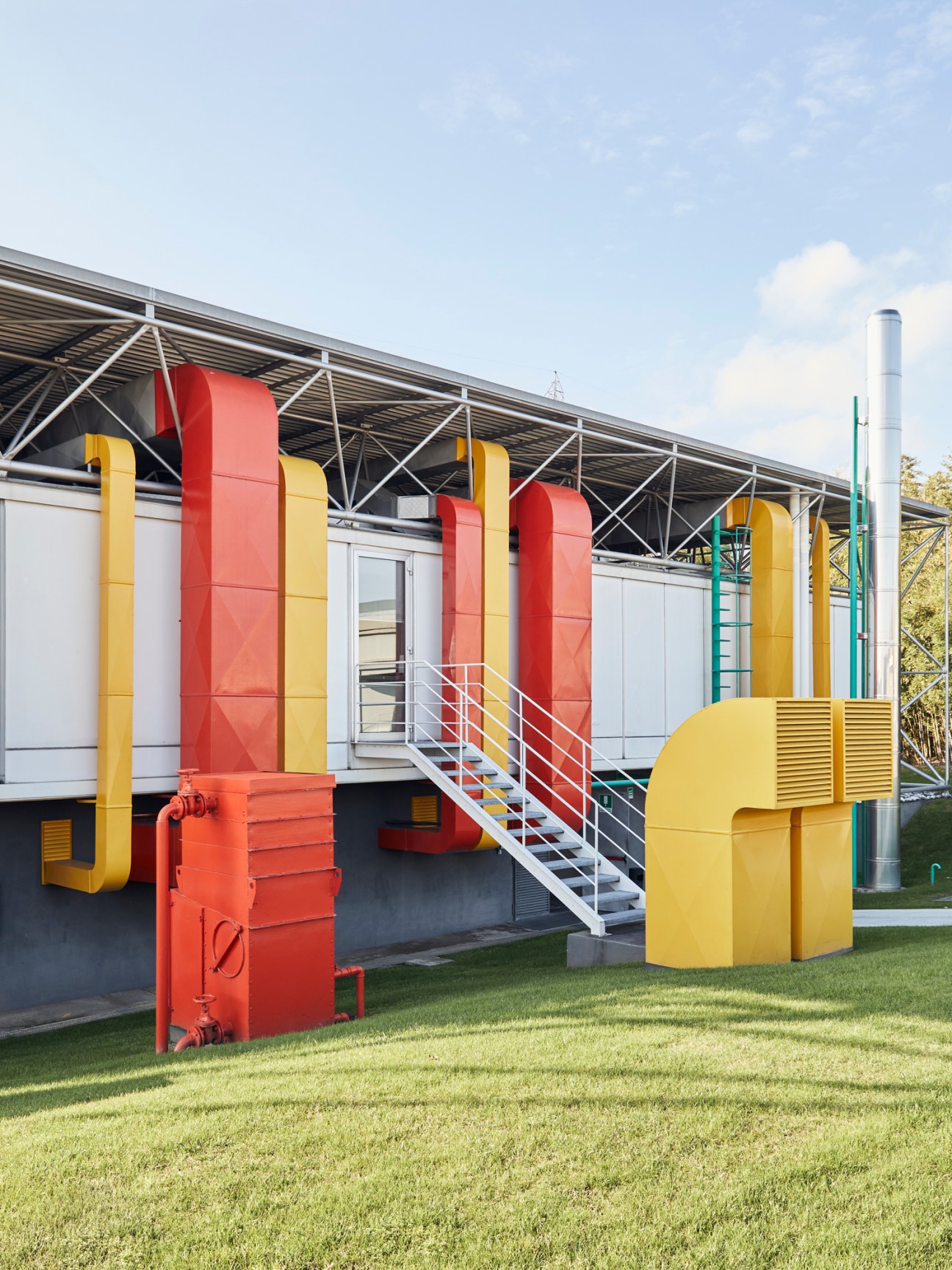 Modern industrial building with colorful red and yellow vertical elements and metal framework