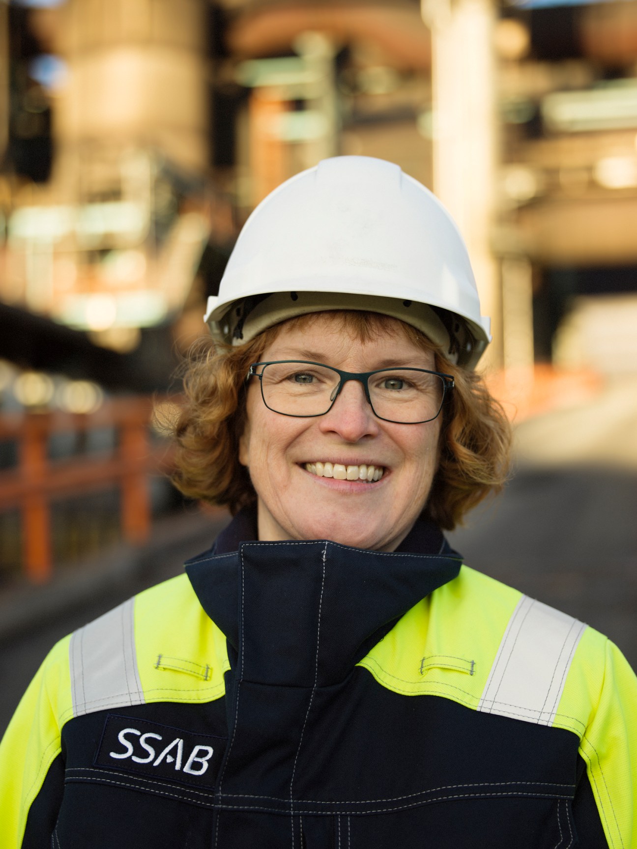 SSAB steel plant employee in safety gear and hard hat at industrial facility