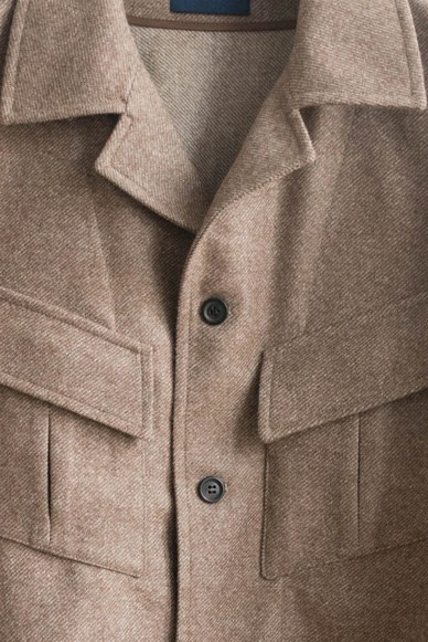 Close-up of beige wool jacket showing lapels, collar and chest pockets with dark buttons