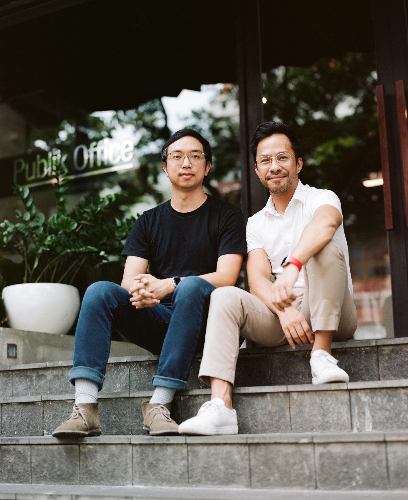 Hao Tran and co-founder of Vietcetera sitting on stone steps outside office