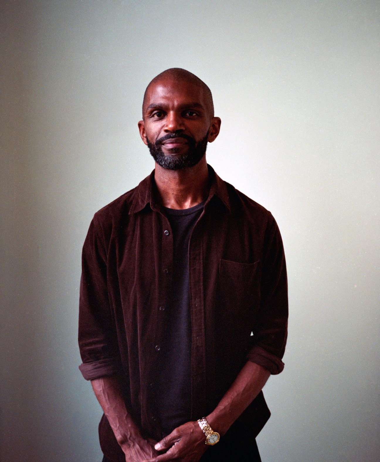 Peter Mabeo, founder of Mabeo Furniture in Botswana, stands against a neutral background wearing a burgundy shirt.