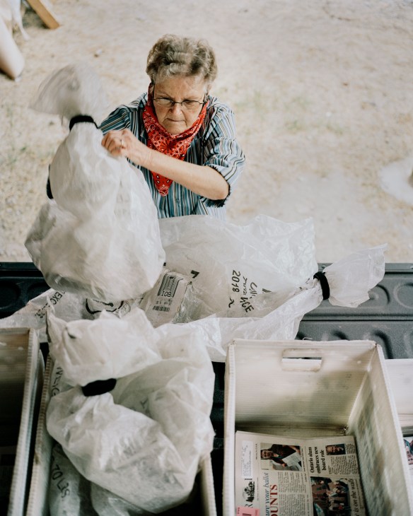 79-year-old woman organising newspapers for weekly delivery route