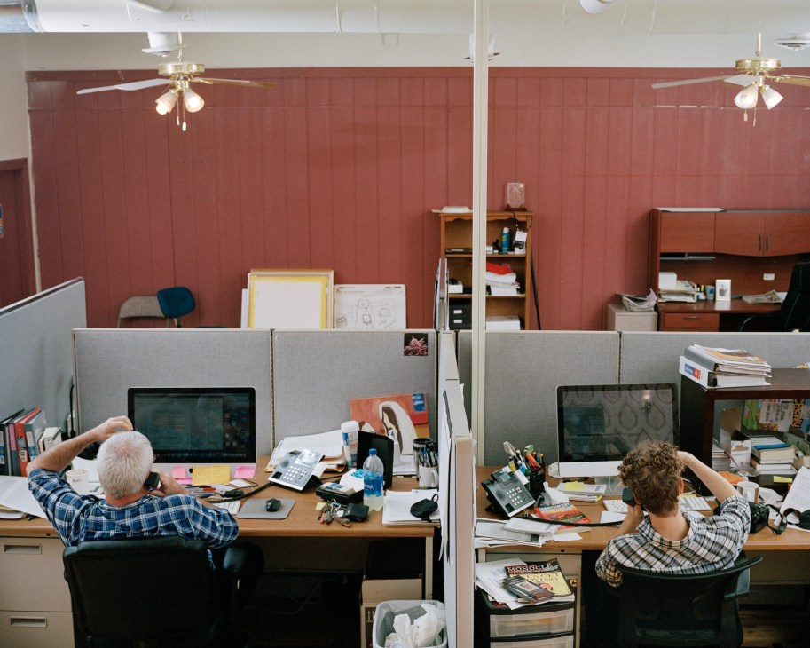 Two reporters working at desks in the Enterprise newspaper office, a former ice cream parlour