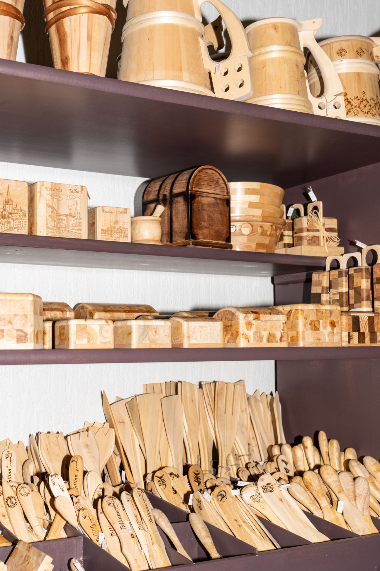 Display of wooden kitchenware, utensils and craft items arranged on shelves at Estonian Handicraft House