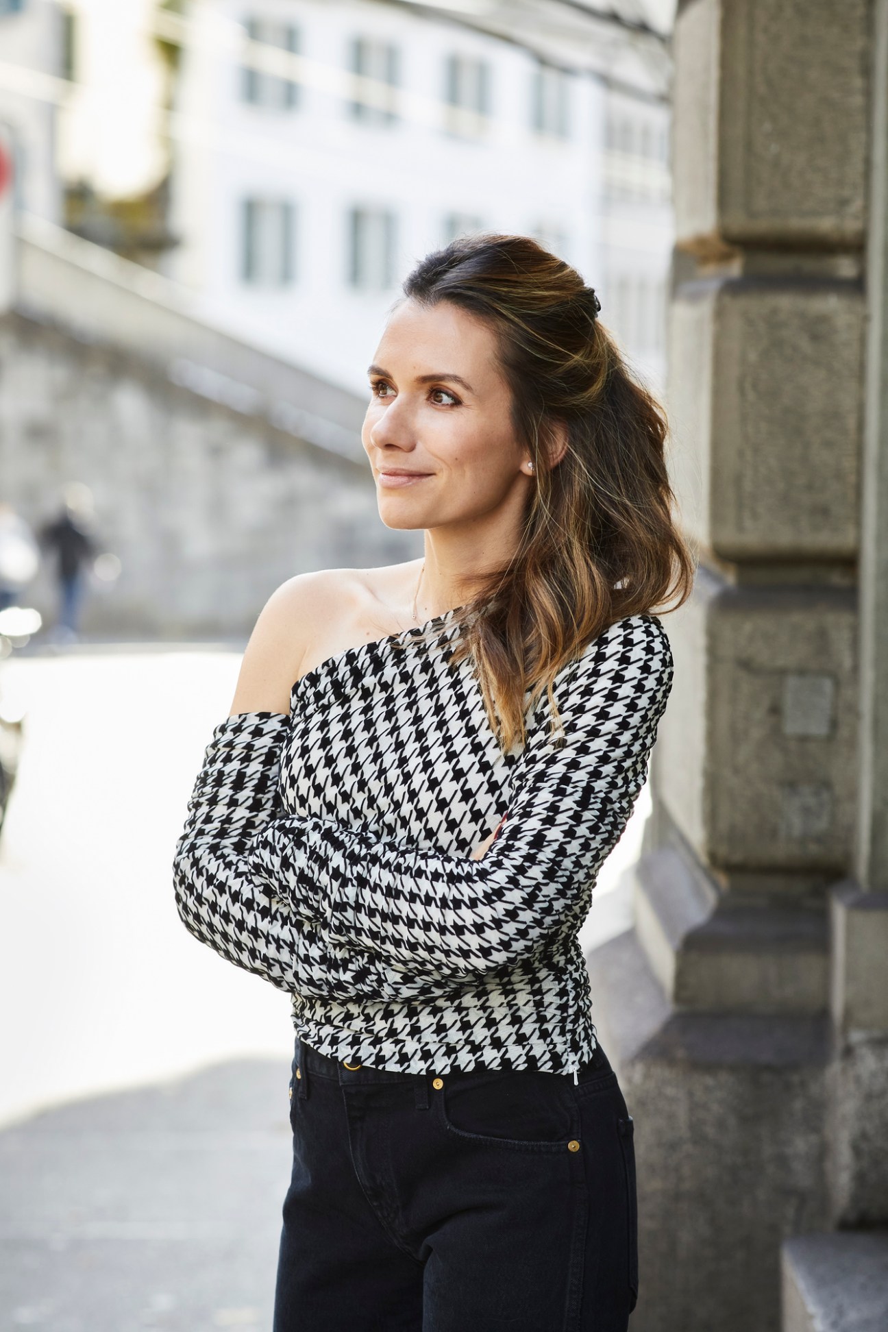 Maria Bernheim standing outdoors in black and white houndstooth top with arms crossed