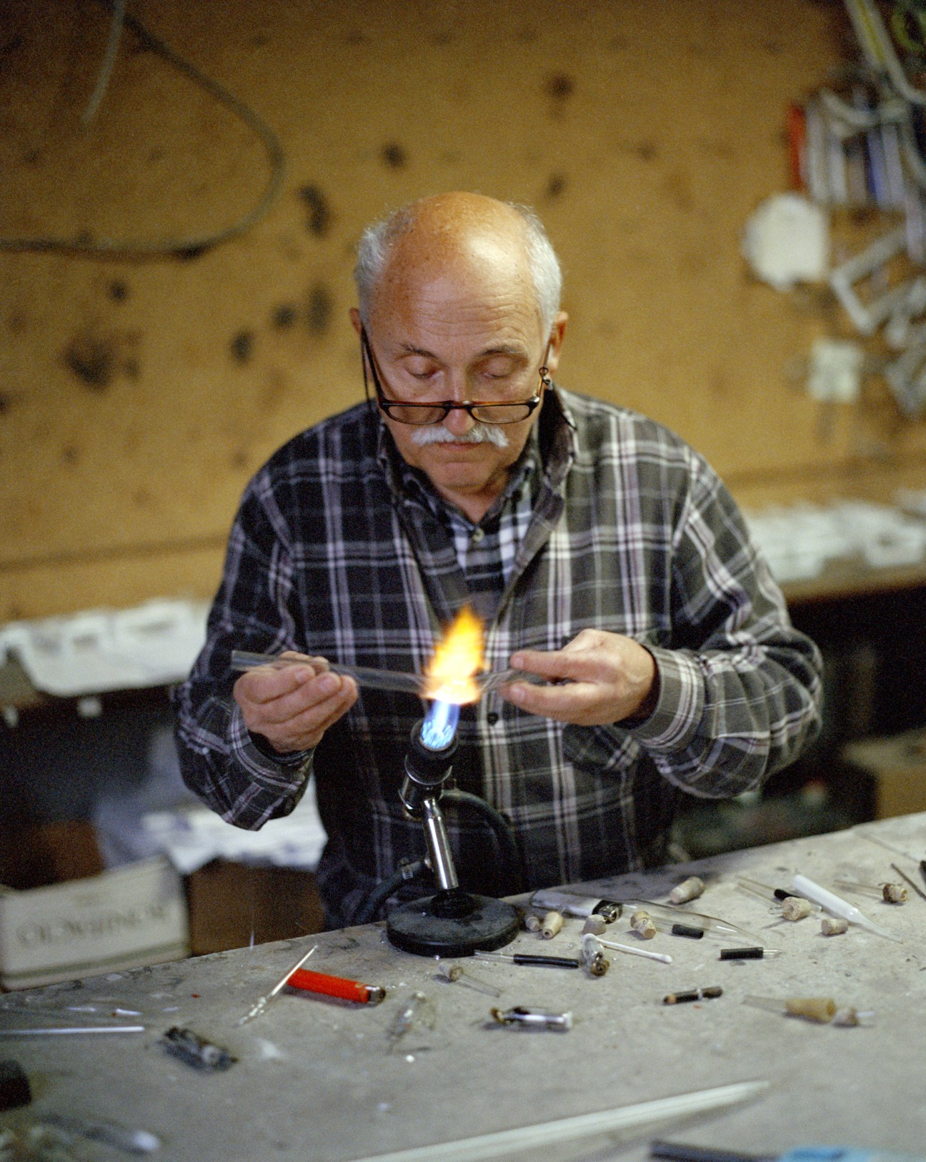 Jorge Neves manually shaping glass with flame in neon workshop