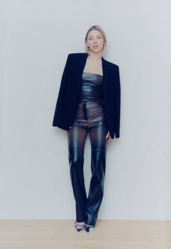 Mary Furtas wearing a black blazer, standing confidently in her workspace