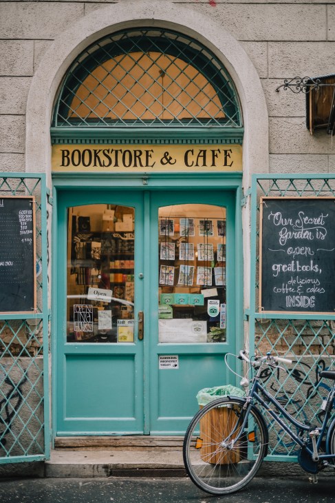 Interior of Massolit Bookstore showing English-language books and café seating