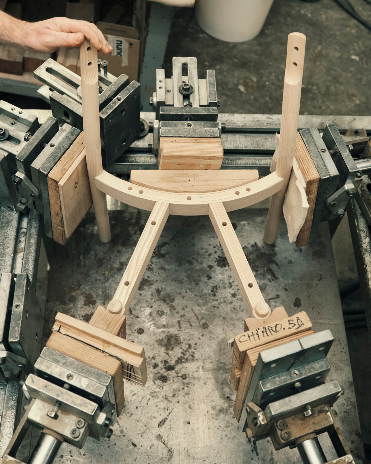Wooden chair components being held in place by industrial clamps during assembly