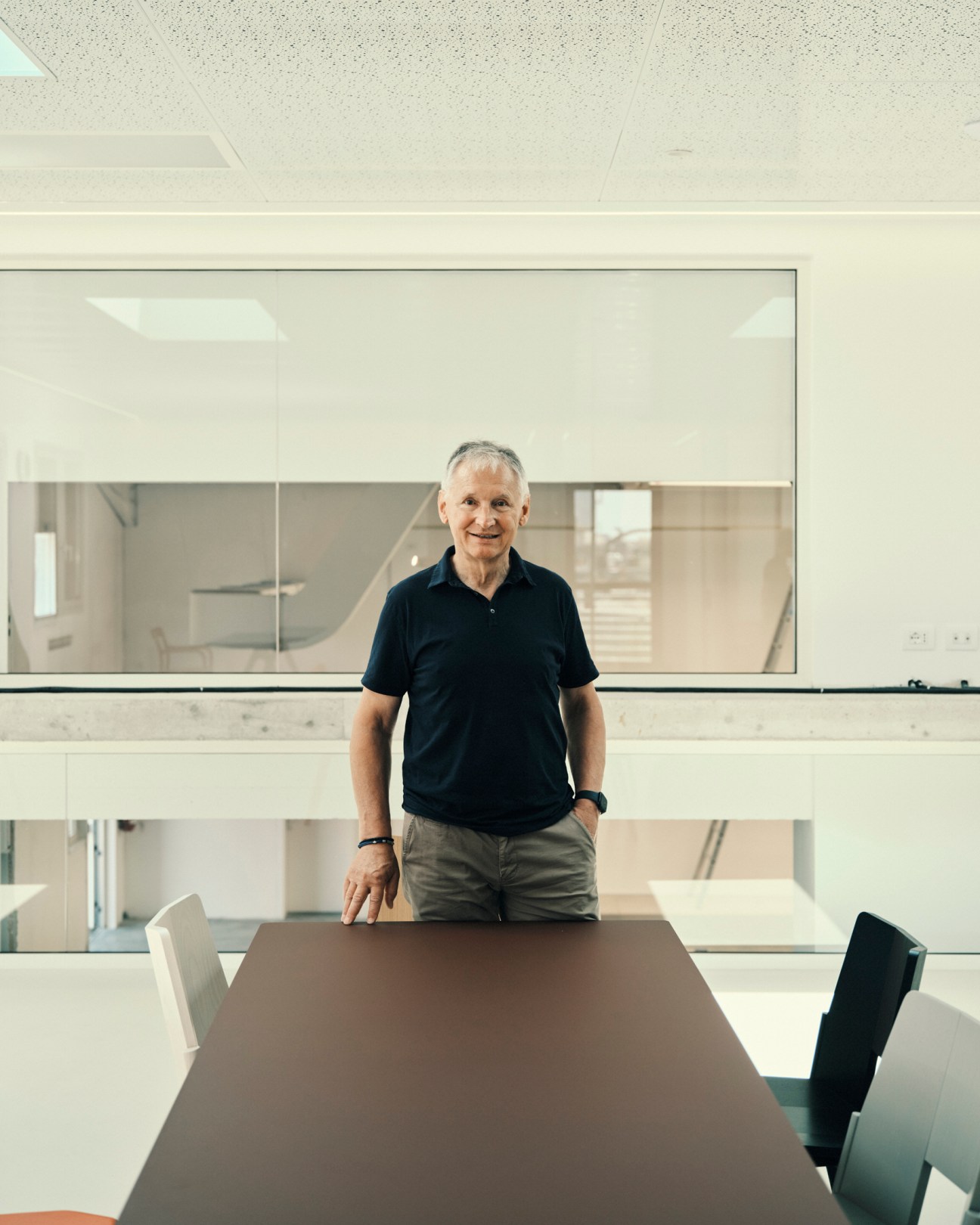 Portrait of company owner Nevio Mattiazzi standing behind a conference table in a modern office setting