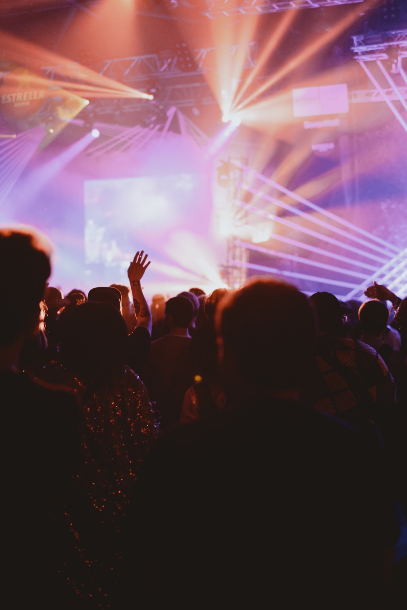 Crowd of people dancing at a concert with purple and orange stage lighting at Sónar Lisbon.