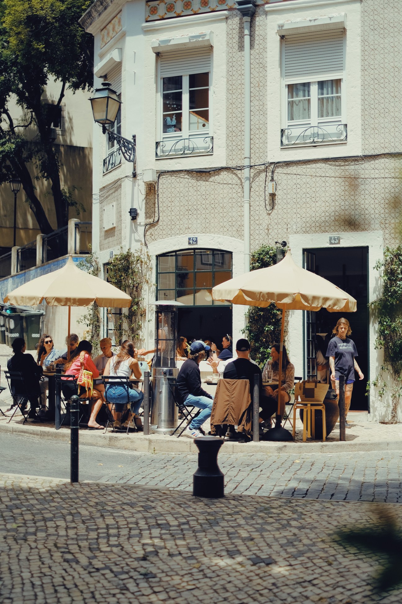 Outdoor café with diners seated under umbrellas on a European street
