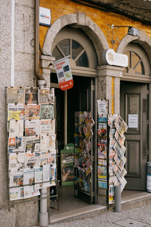 Street-level view of a historic storefront with arched stone entrance in Guimarães, Portugal.