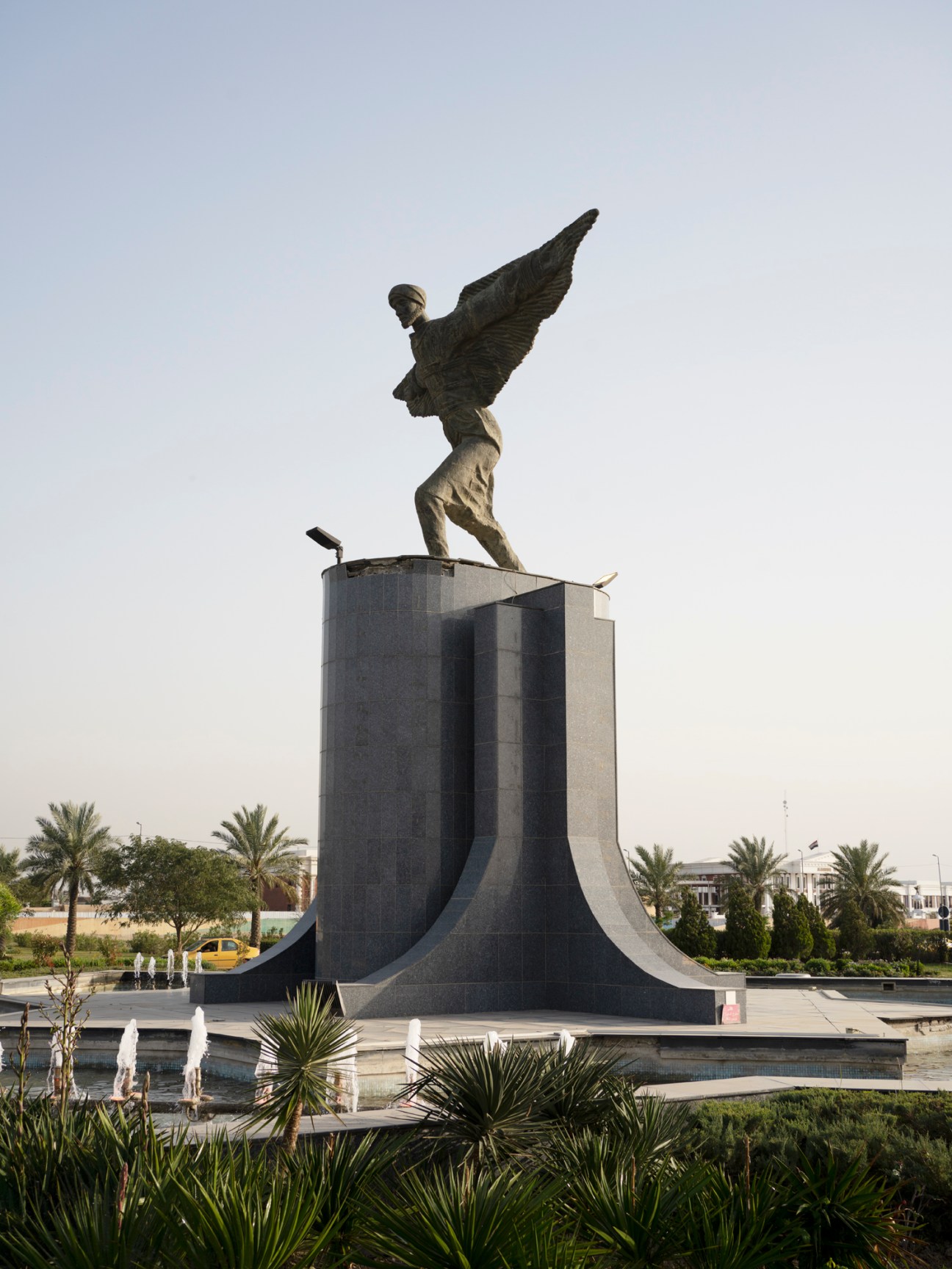 Monument featuring bronze winged figure on geometric concrete base in Abbas Ibn Firnas Square, Baghdad