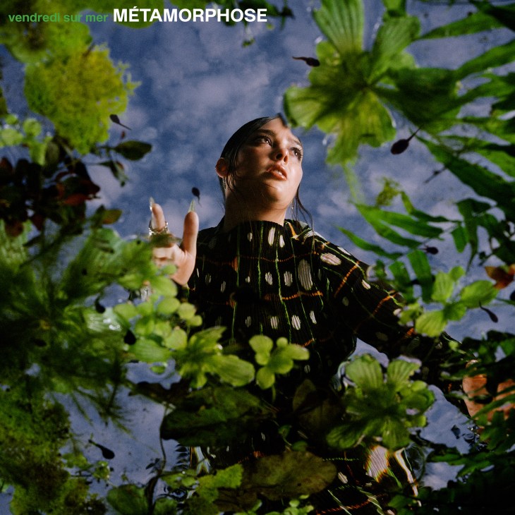 Woman surrounded by green foliage looking upward, album cover for Métamorphose by Vendredi sur Mer