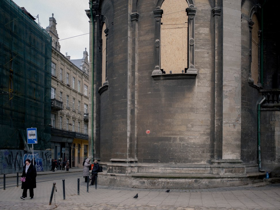 Historic church in central Lviv with wooden panels installed over windows for protection against war damage