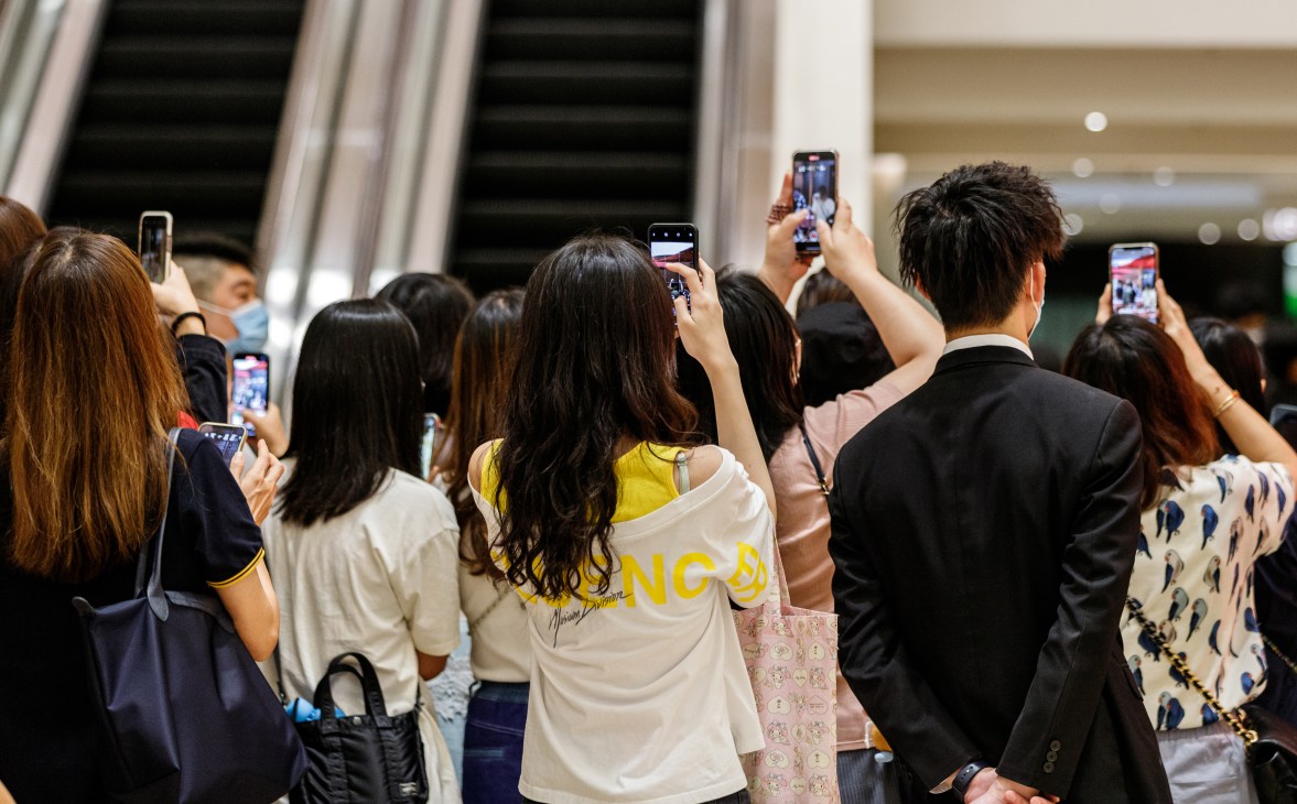 Crowd of Mirror fans holding up smartphones to record at a shopping mall event