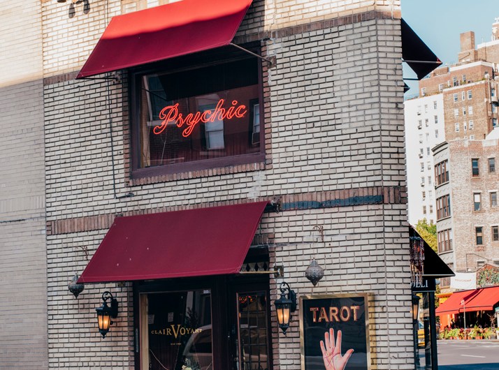 Zena Clairvoyant storefront in West Village with red awnings, neon psychic sign, and tarot palm sign.