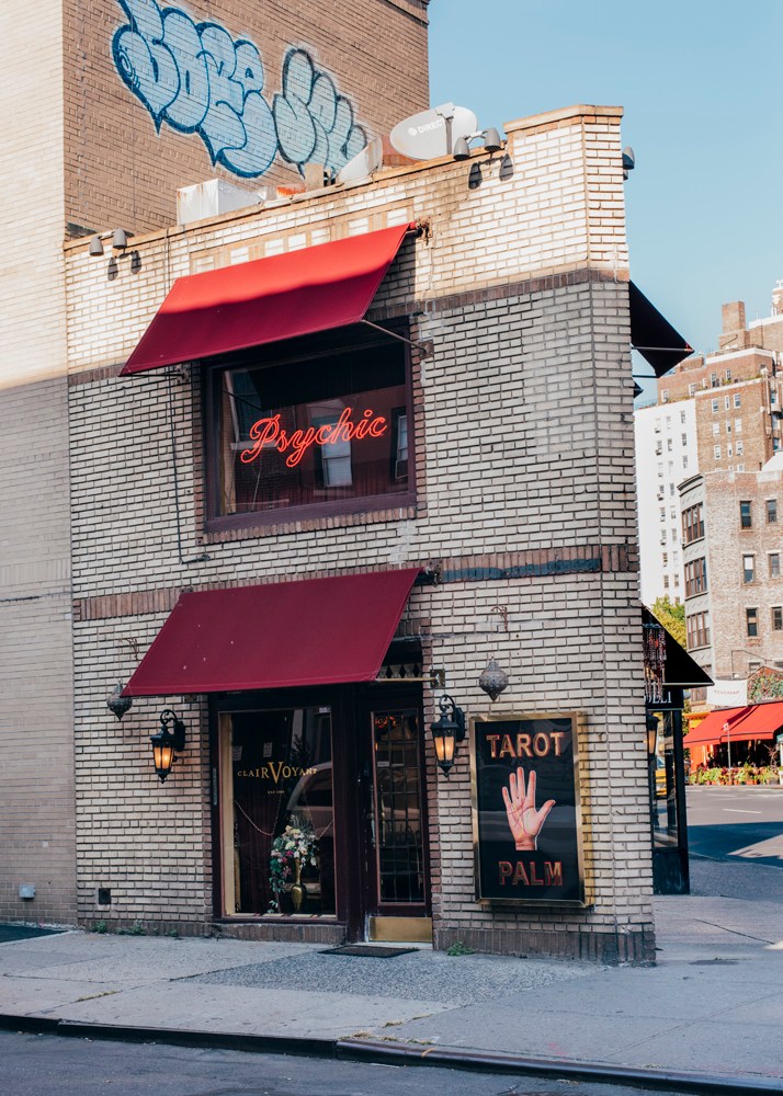 Zena Clairvoyant storefront in West Village with red awnings, neon psychic sign, and tarot palm sign.