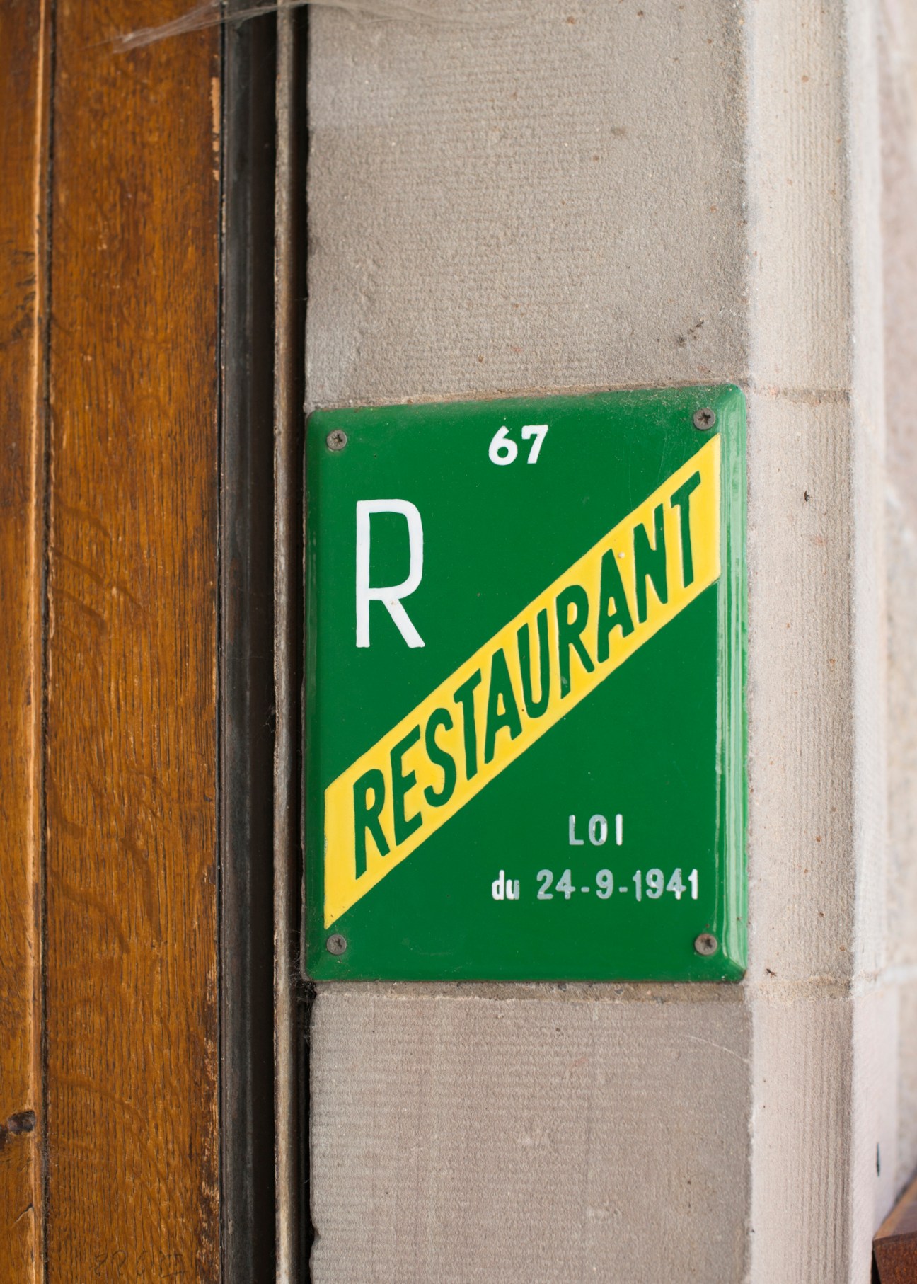 Green restaurant sign with white R and yellow RESTAURANT text, marked number 67 and dated LOI du 24-9-1941