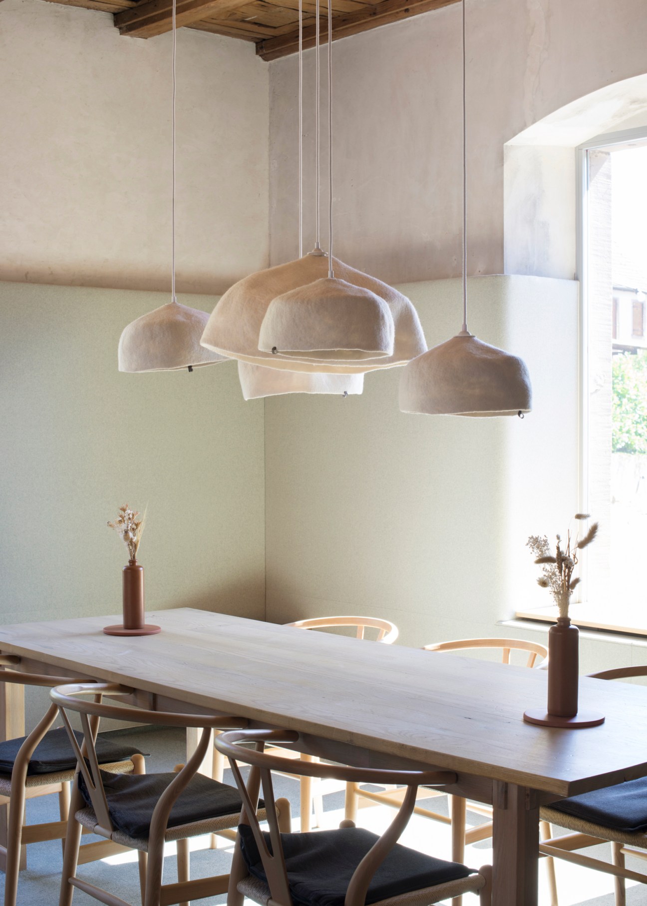 Modern dining room at Enfin restaurant with pendant lights, wooden table, chairs and neutral decor