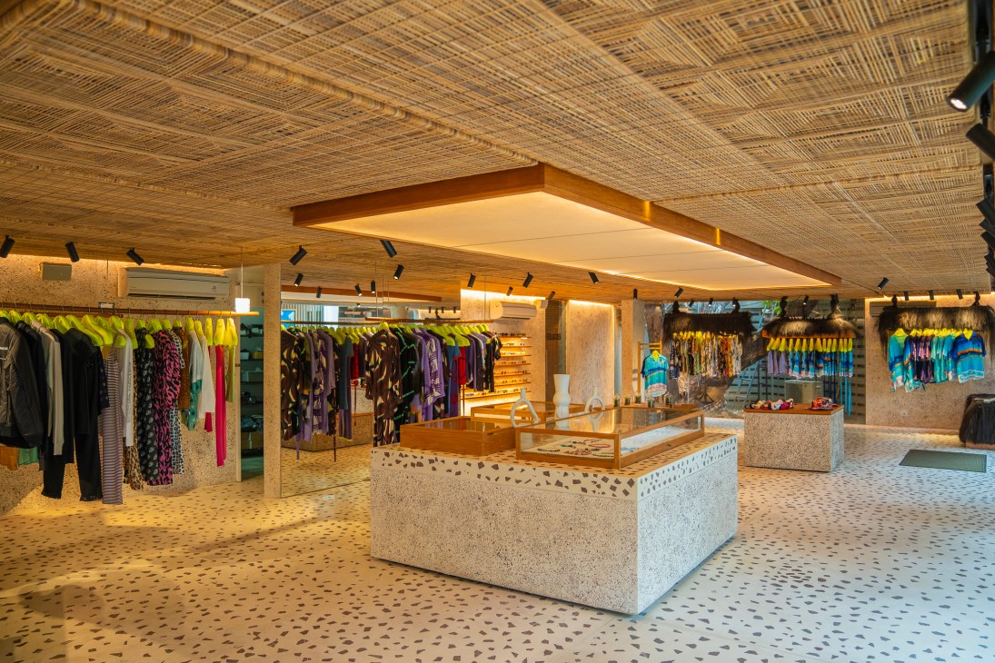 Interior of Escalier boutique showing clothing racks, terrazzo floor, woven bamboo ceiling, and central display counter