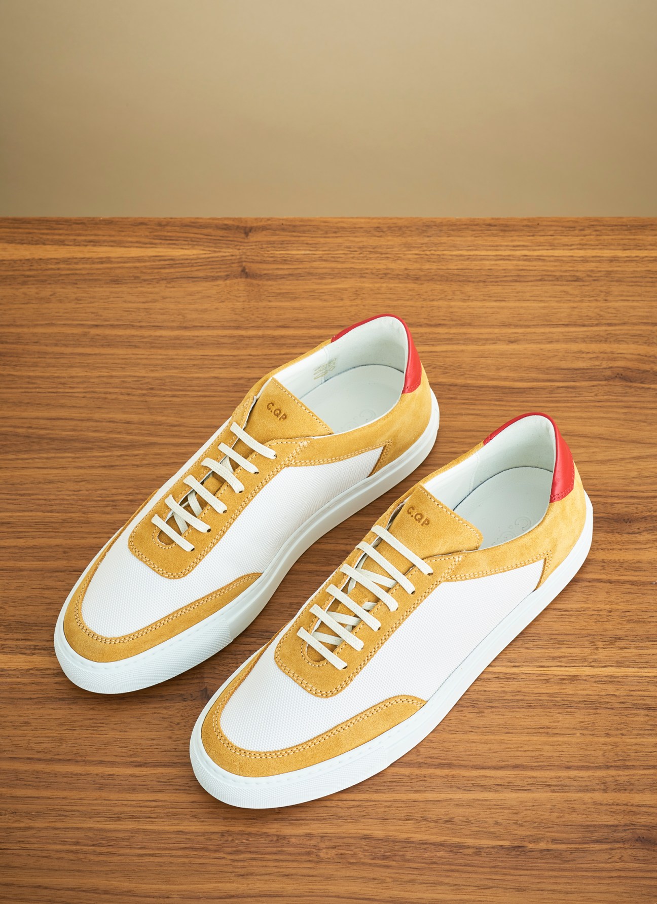 CQP Atrium sneakers in yam yellow and white colorway on wooden floor