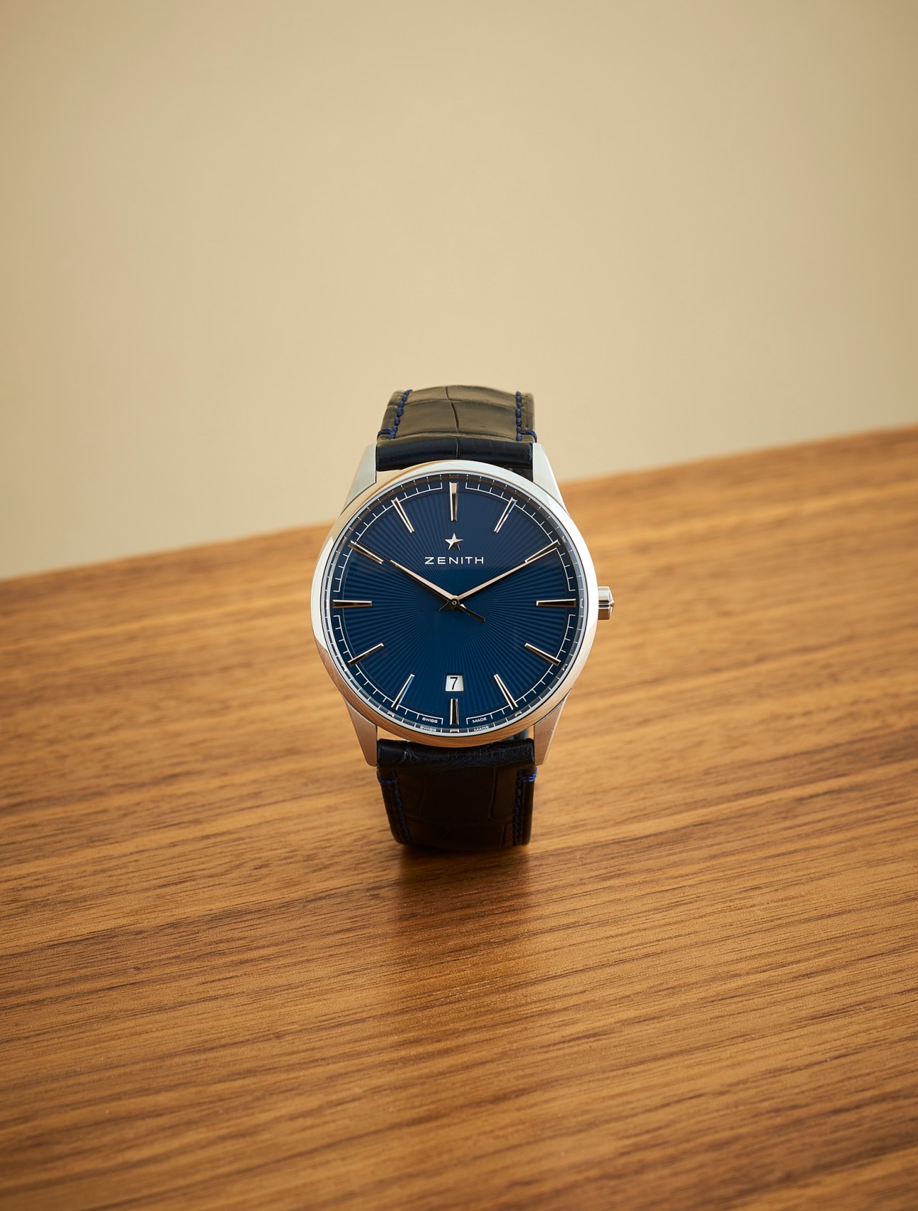 Zenith Elite Classic watch with blue dial and leather strap on wooden surface