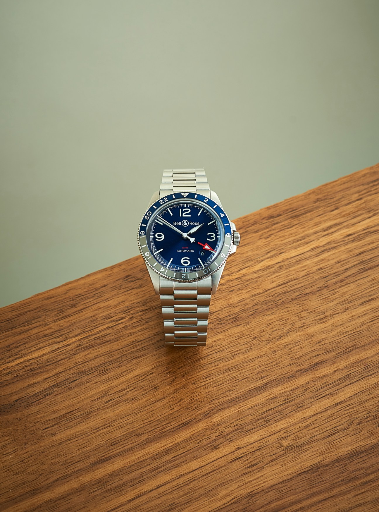 Bell & Ross BR V2-93 GMT Blue watch with blue dial and steel bracelet on wooden surface