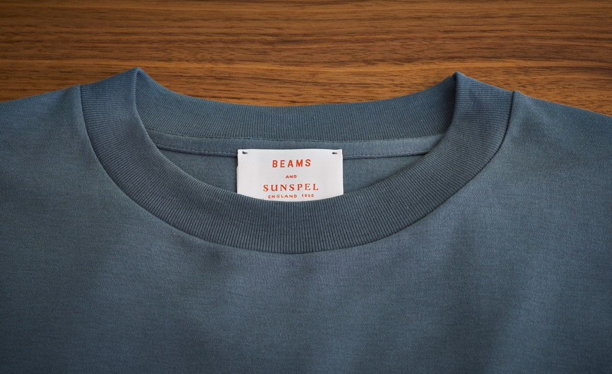 Close-up of gray t-shirt collar showing Beams and Sunspel collaboration label