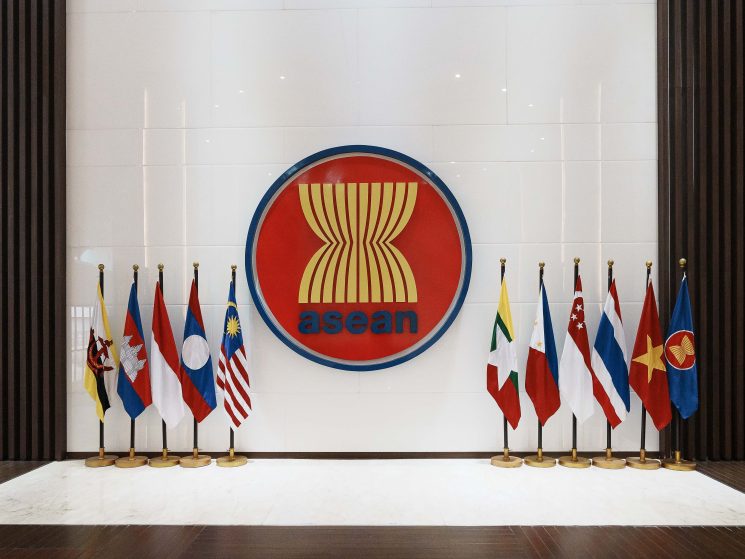 Flags of Asean's 10 member states displayed in the secretariat's lobby with the organization's logo on the wall