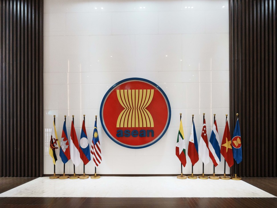 Flags of Asean's 10 member states displayed in the secretariat's lobby with the organization's logo on the wall