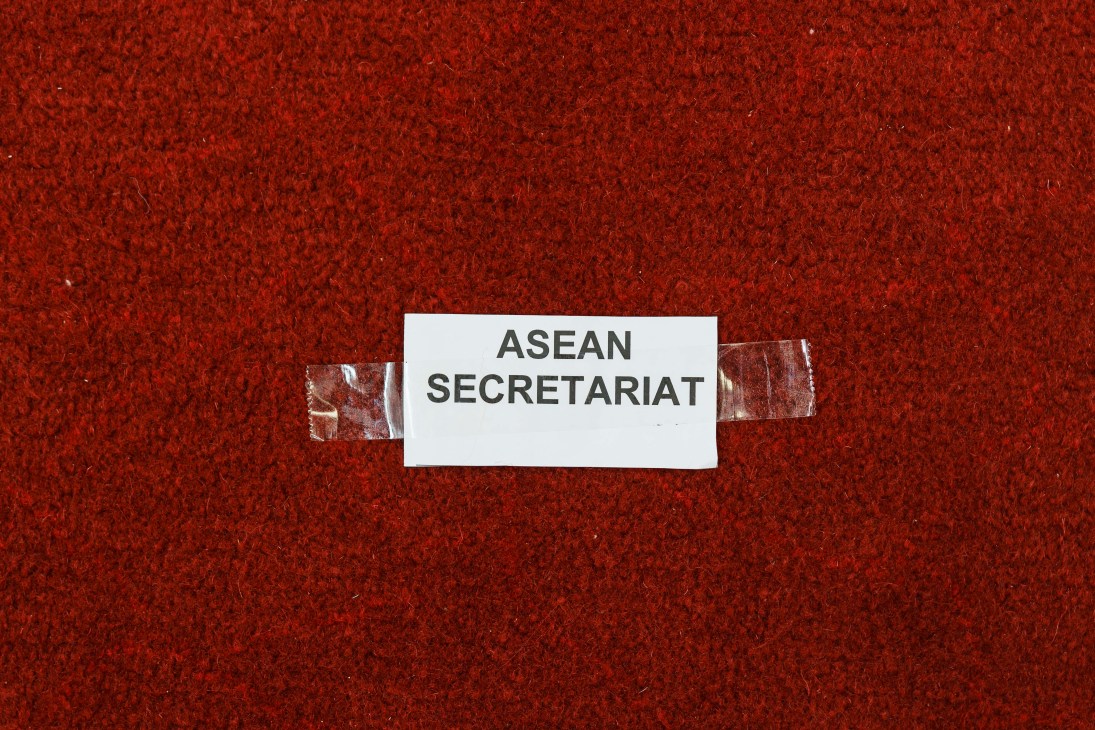 Close-up of clear adhesive tape on a red textured surface with white label reading ASEAN SECRETARIAT