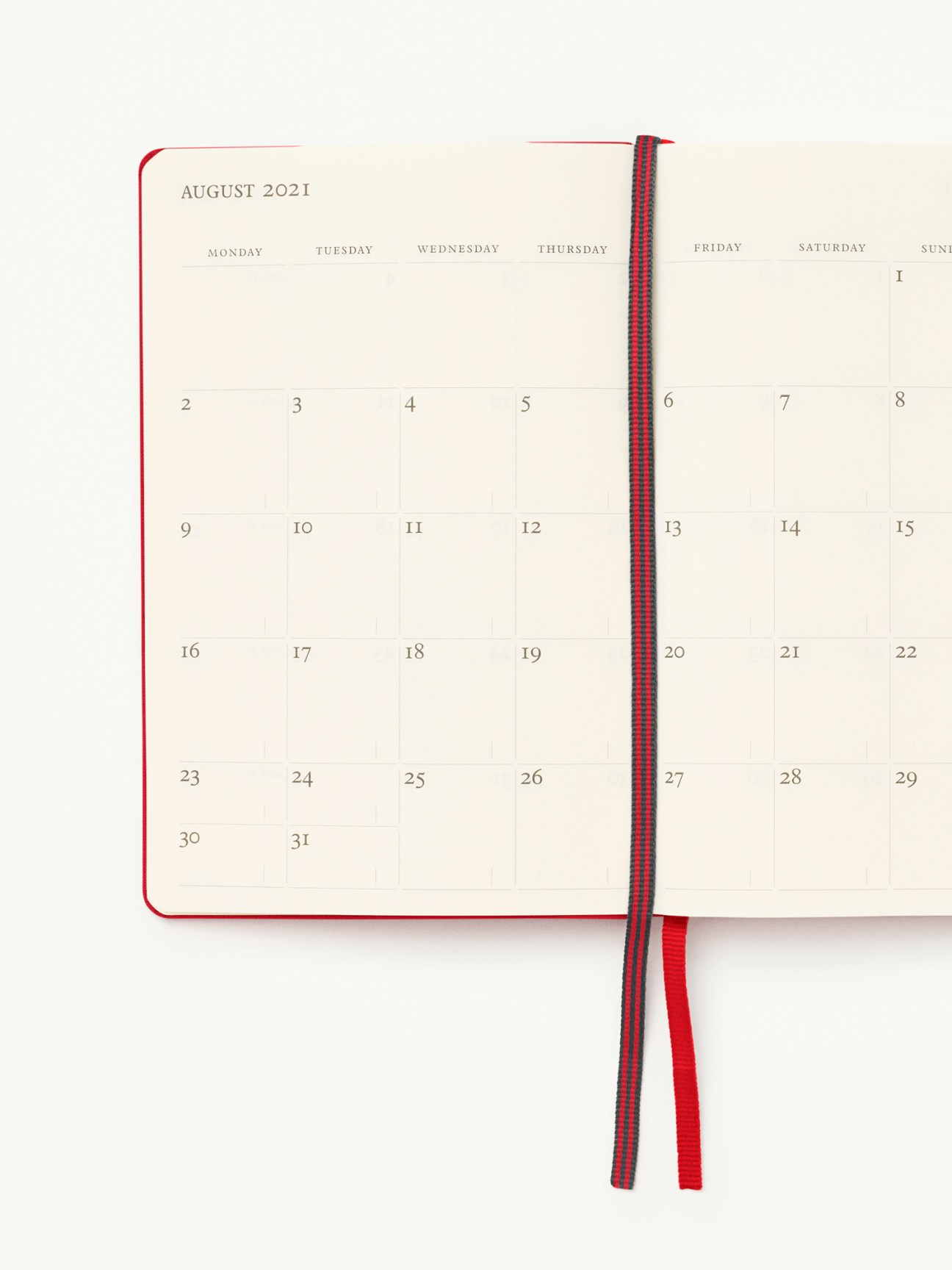 Leuchtturm1917 x Monocle weekly diary 2021 in red showing August calendar spread with ribbon bookmark.