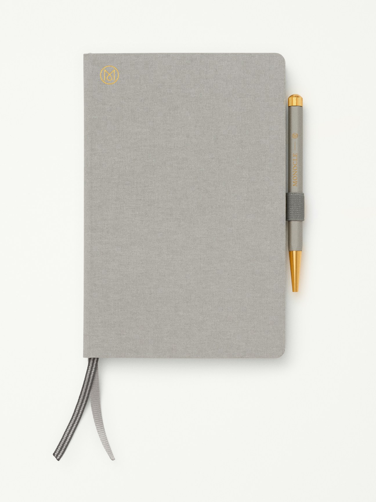 Grey notebook with attached pen and pen loop against white background