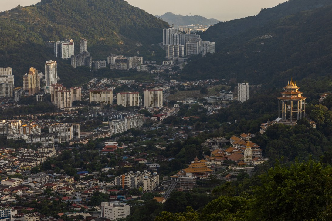 Aerial view of George Town from Penang Hill showing dense urban development nestled between forested hills