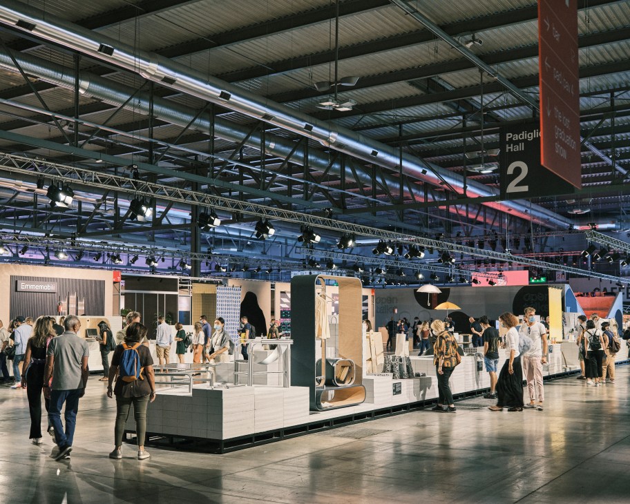 The Lost Graduation Show exhibition space with white display platforms and visitors at Supersalone