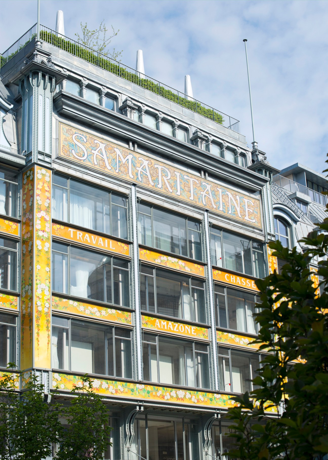 Historic Parisian building facade with ornate Samaritaine signage and decorative orange floral details