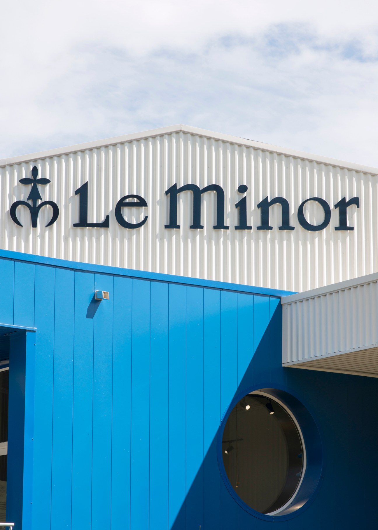 Le Minor factory building with blue and white corrugated metal exterior and company signage