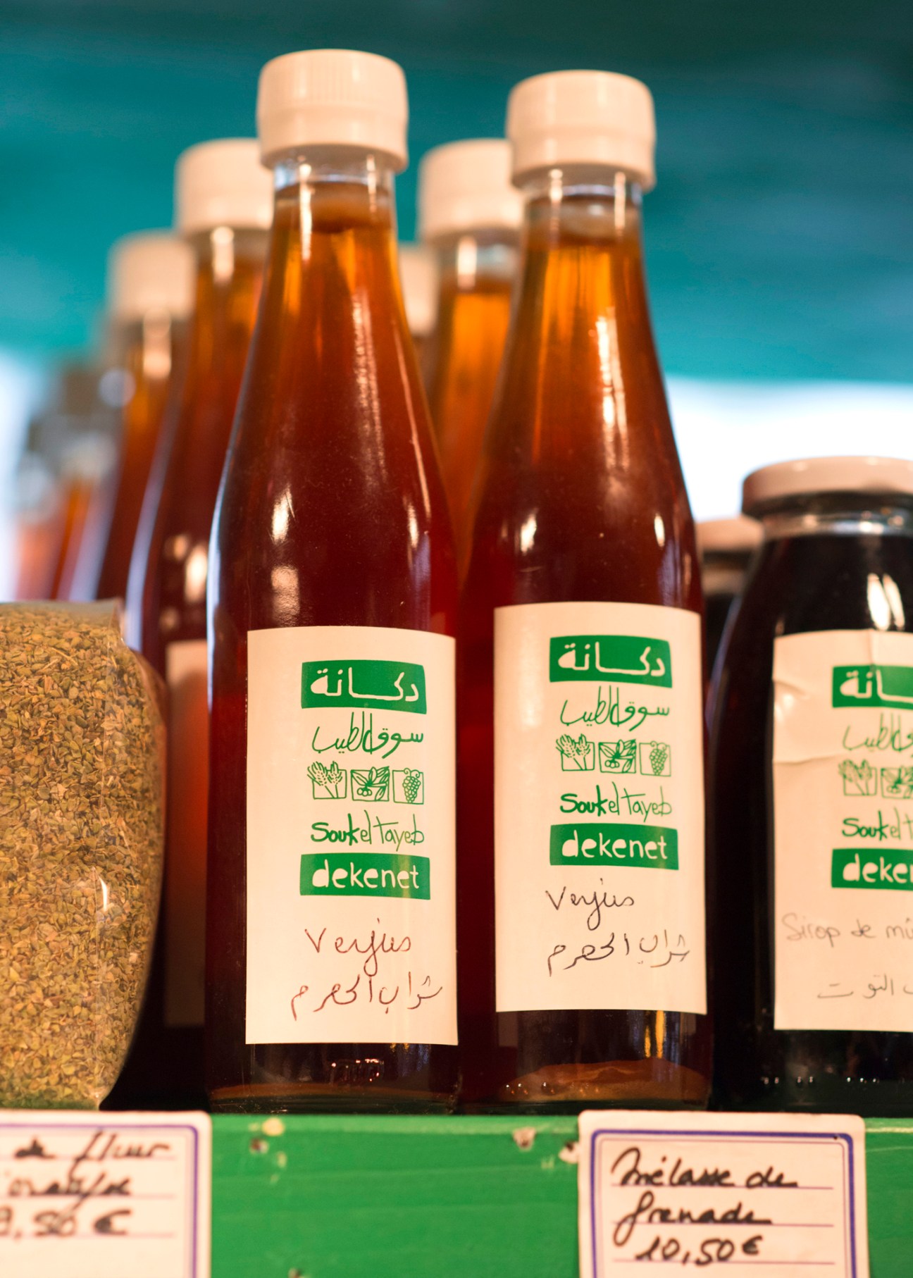 Brown glass bottles with Arabic labels displaying Souk el Tayeb products for sale at Tawlet Paris