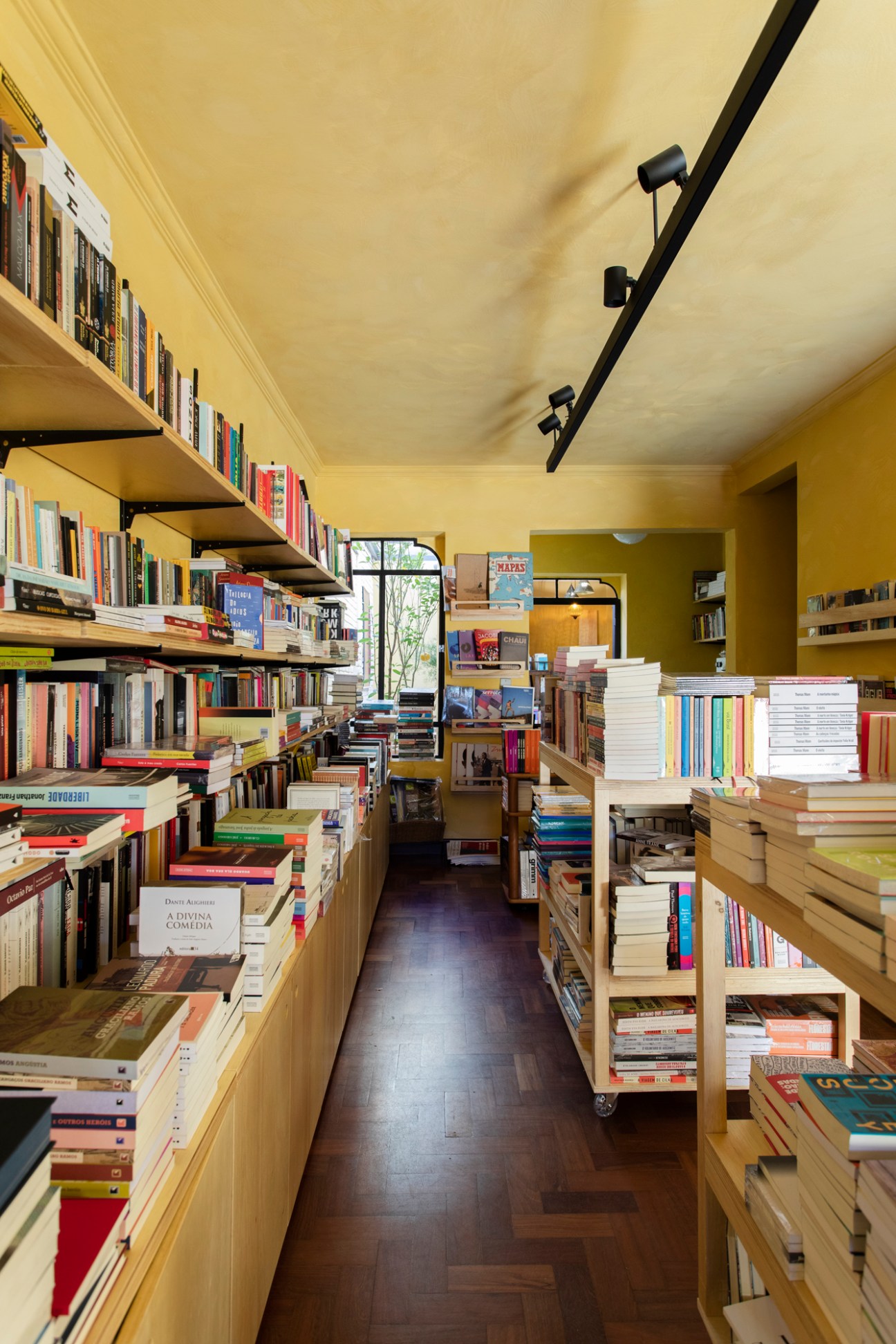 Interior of independent bookshop with wooden shelves, books displayed on tables, and cozy reading atmosphere
