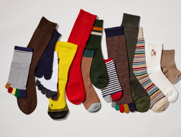 Colorful array of various socks in different patterns, colors and styles arranged on white background
