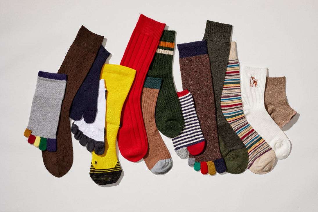 Colorful array of various socks in different patterns, colors and styles arranged on white background
