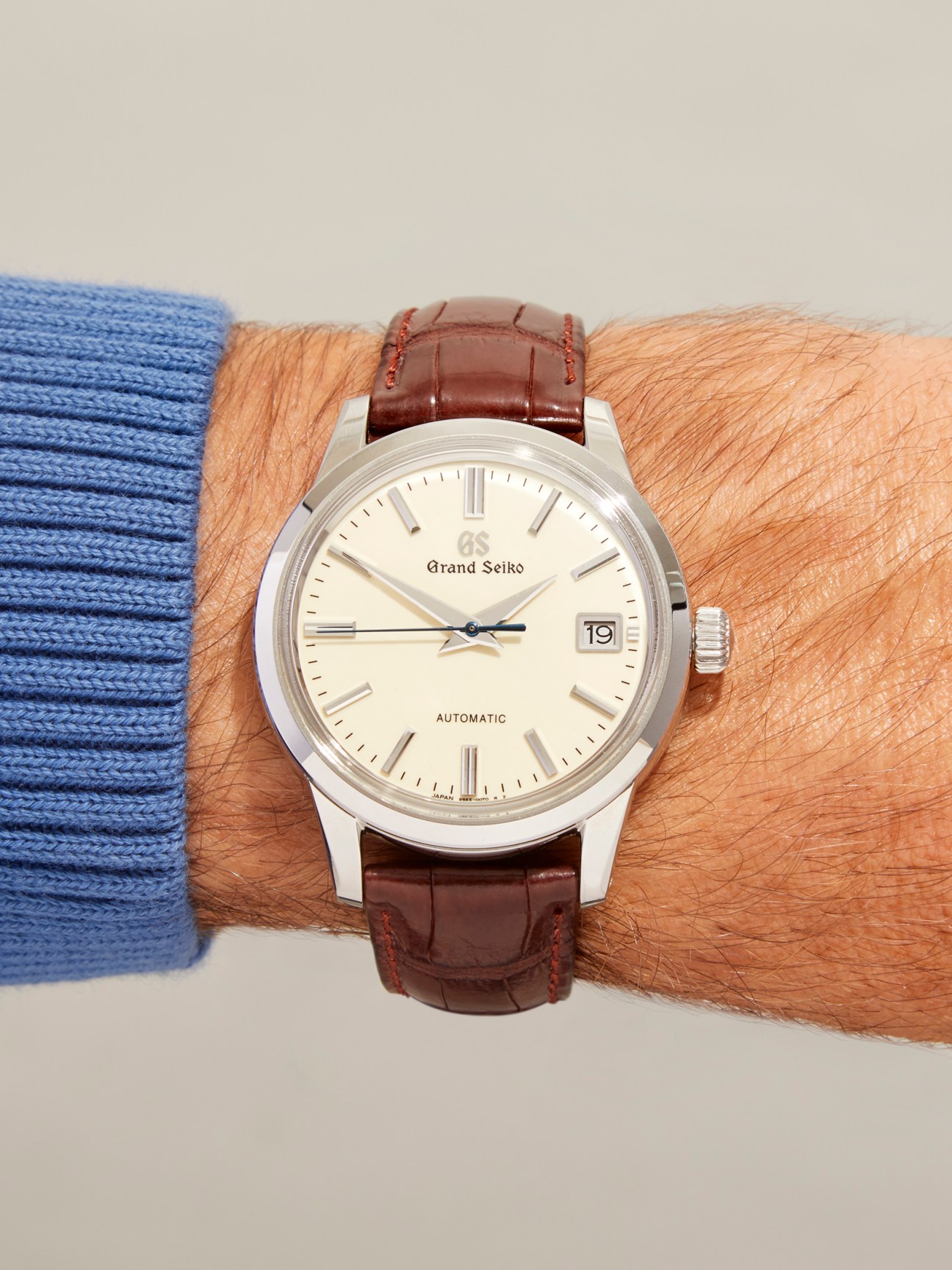 Grand Seiko mechanical automatic watch with cream dial and brown leather strap worn on wrist