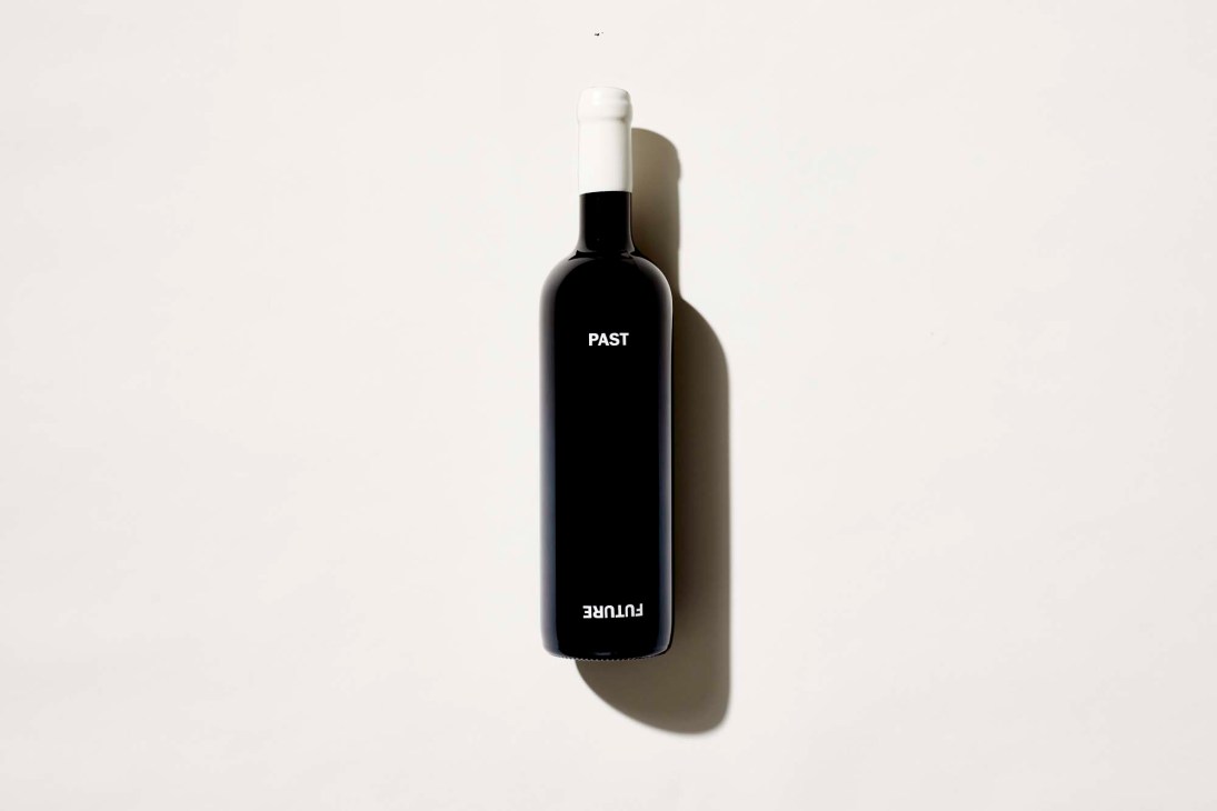 Minimalist black wine bottle with white text reading 'PAST' and 'FUTURE' against neutral background